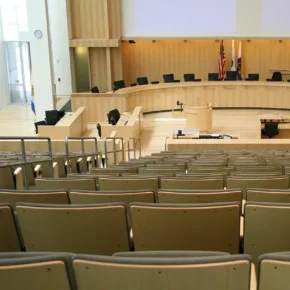 Vip technology supporting local government meeting room with light brown chairs and stage